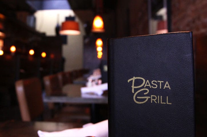 A Pasta Grill menu propped up on a table inside Pasta Grill.